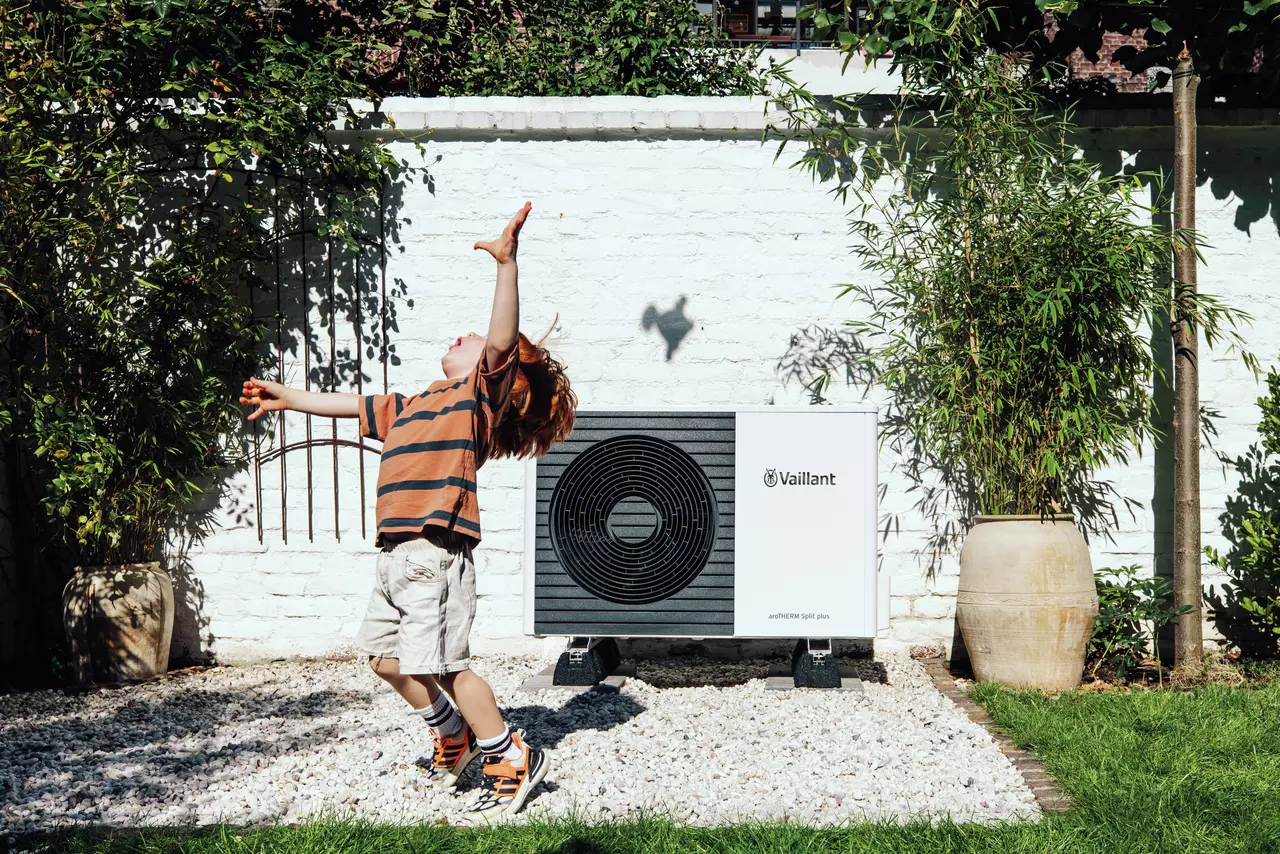 Niño jugando delante de una bomba de calor Vaillant