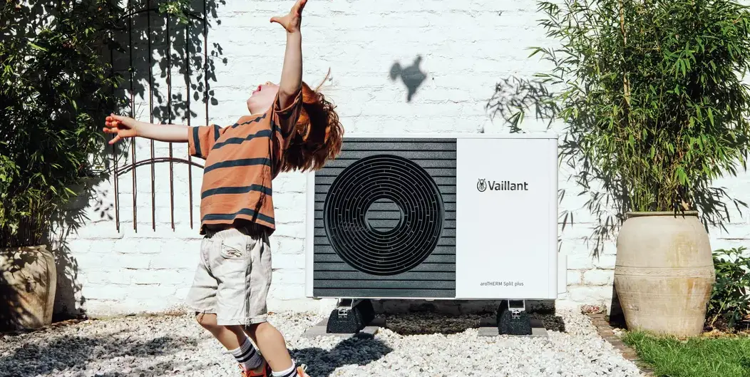 Niño jugando delante de una bomba de calor Vaillant